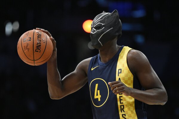 
              Indiana Pacers' Victor Oladipo gets ready for a dunk while wearing a mask from the movie "Black Panther" during the NBA All-Star basketball slam dunk contest Saturday, Feb. 17, 2018, in Los Angeles. (AP Photo/Chris Pizzello)
            