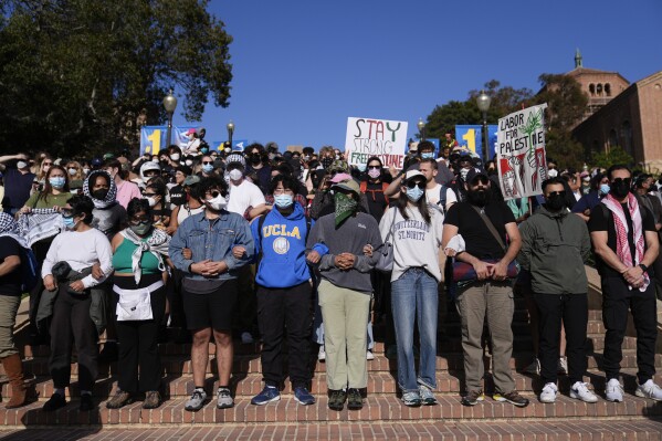 Demonstrators lock arms on the UCLA campus, after nighttime clashes between Pro-Israel and Pro-Palestinian groups, Wednesday, May 1, 2024, in Los Angeles. (AP Photo/Jae C. Hong)