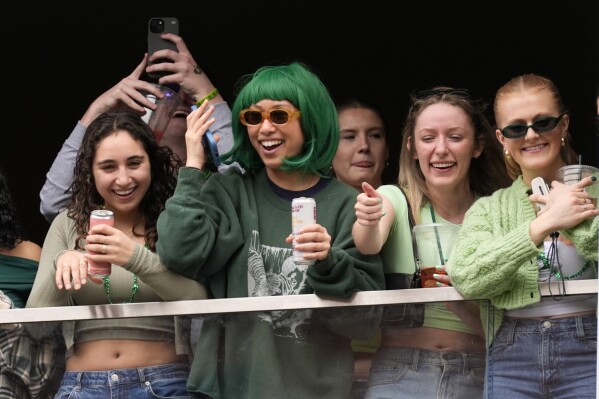 Spectators watch the St. Patrick's Day parade from a balcony, Sunday, March 16, 2025, in Boston, Mass. (AP Photo/Robert F. Bukaty)