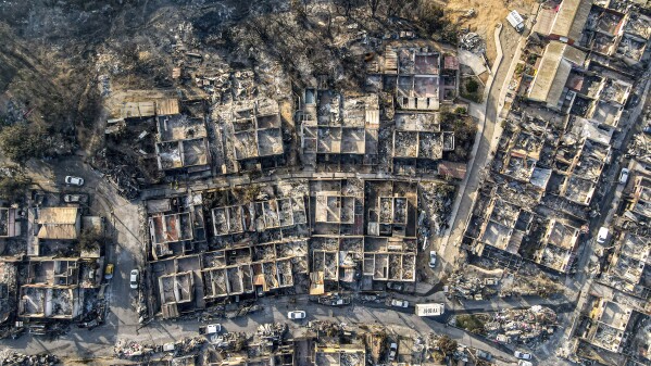 Homes are left in ruins after forest fires blazed through the El Olivar neighborhood in Vina del Mar, Chile, Monday, Feb. 5, 2024. (AP Photo/Esteban Felix)