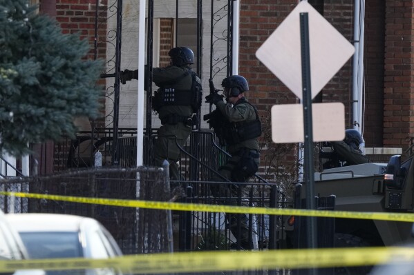 Law enforcement officers enter an empty apartment home, in Trenton, N.J., Saturday, March 16, 2024. A man suspected of killing several people in their Philadelphia-area homes was arrested in New Jersey's capital city following a major police response, authorities said. (AP Photo/Matt Rourke)