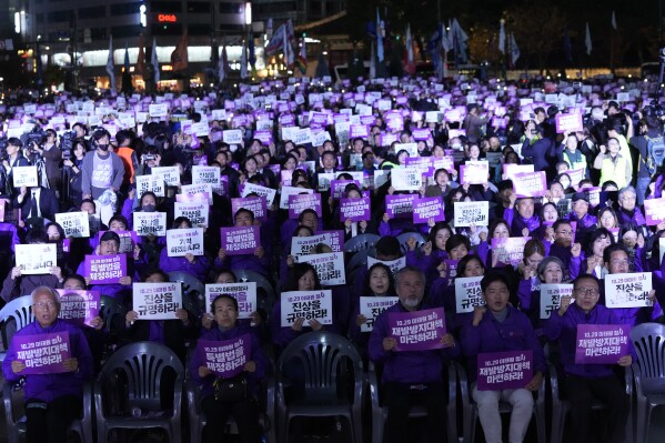 People hold the signs during a rally marking the first anniversary of the harrowing crowd surge that killed about 160 people in a Seoul alleyway, at the Seoul Plaza in Seoul, South Korea, Sunday, Oct. 29, 2023. The signs read 