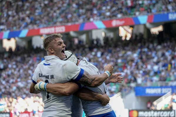 Italy's Manuel Zuliani ,right, celebrates his try with Italy's Lorenzo Cannot during the Rugby World Cup Pool A match between Italy and Namibia at the Geoffroy Guichard stadium in Saint-Etienne, central France, Saturday, Sept. 9, 2023. (AP Photo/Laurent Cipriani)