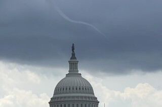 This photo provided by Peter Kiley shows a small funnel cloud over the U.S. Capitol dome on Tuesday, July 25, 2023 in Washington. (Peter Kiley via AP)
