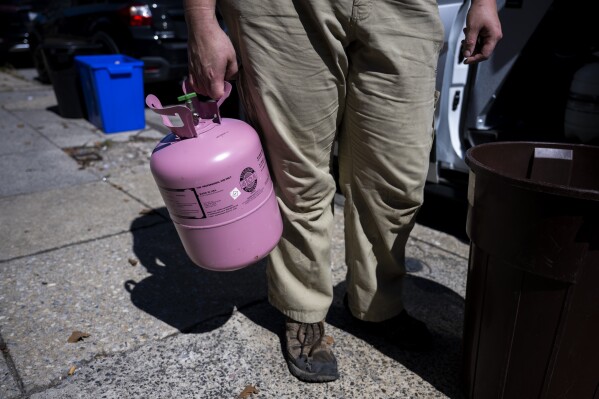 Jennifer Byrne, owner and technician at Comfy Heating and Cooling, pulls a tank of refrigerant from the work truck in Philadelphia on Thursday, Sept. 14, 2023. (AP Photo/Joe Lamberti)