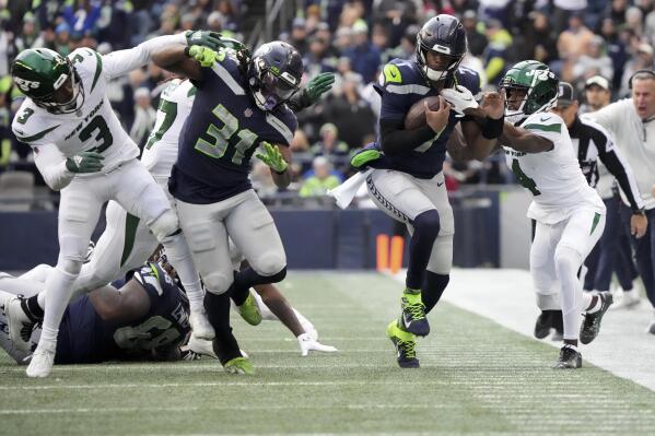 Seattle Seahawks quarterback Geno Smith runs for a first down as New York Jets cornerback D.J. Reed (4) defends during the first half of an NFL football game, Sunday, Jan. 1, 2023, in Seattle. (AP Photo/Ted S. Warren)