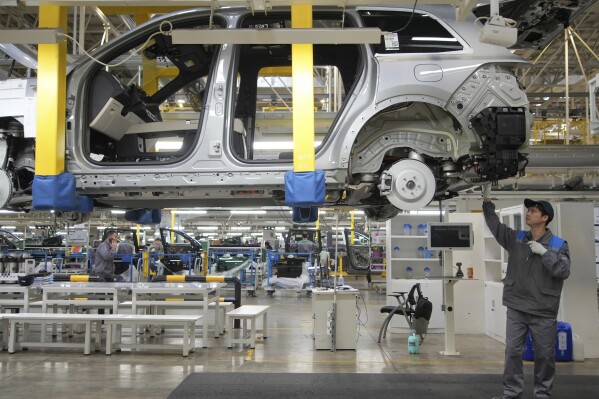 A worker assembles an SUV at a car plant of Li Auto, a major Chinese EV maker, in Changzhou in eastern China's Jiangsu province on Wednesday, March 27, 2024. Manufacturing in China expanded in March after contracting for five consecutive months, according to an official survey of factory managers released Sunday, suggesting a rebound in industrial activities following the Lunar New Year holiday. (Chinatopix Via AP)