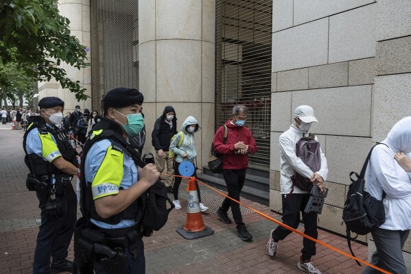 Ludzie ustawiają się w kolejce przed sądem pokoju West Kowloon w Hongkongu przed wydaniem wyroku w sprawie dotyczącej bezpieczeństwa narodowego, czwartek, 30 maja 2024 r.  (Zdjęcie AP/Chan Long Hai)