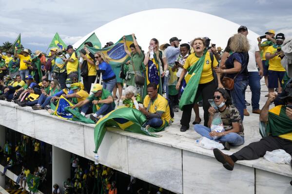 FILE - Protesters, supporters of Brazil's former President Jair Bolsonaro, stand on the roof of the National Congress building after they stormed it, in Brasilia, Brazil, Sunday, Jan. 8, 2023. (AP Photo/Eraldo Peres, File)