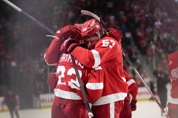 Detroit Red Wings left wing Lucas Raymond (23) celebrates with Moritz Seider (53) after his goal against the Montreal Canadiens in overtime during an NHL hockey game Monday, April 15, 2024, in Detroit. (AP Photo/Paul Sancya)