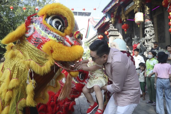 Local Chinese present a red envelop, or hongbao, to lion dance performers during a cerebration to mark the Lunar New Year at Chinatown Saturday, Feb. 10, 2024, in Yangon, Myanmar. (APPhoto/Thein Zaw)