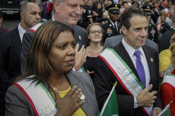 FILE - This Saturday, Sept. 13, 2014 file photo, shows New York City Mayor Bill de Blasio, center, standing behind New York Gov. Andrew Cuomo, right, and Attorney General Letitia James, left, at the time the city's public advocate, during the 88th Annual Feast of San Gennaro Grand Procession in New York. Gov. Cuomo $18 million campaign war chest suggest he's seen a dip in financial support. James, a Democrat who has not said whether she's running for governor in 2022, reported that her campaign war chest is at $1.6 million. (AP Photo/Frank Franklin II, File)