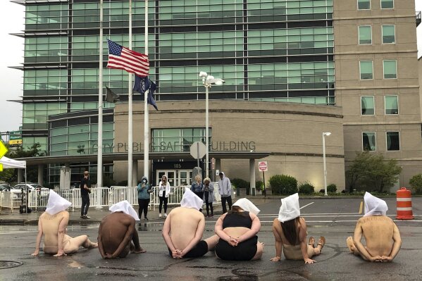 Naked protesters, wearing "spit hoods" in reference to the killing of Daniel Prude, demonstrate outside Rochester's Public Safety Building in Rochester, N.Y., Monday, Sept. 7, 2020. (Tracy Schuhmacher/Democrat & Chronicle via AP)