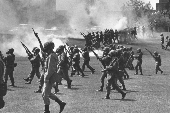 FILE - Ohio National Guard soldiers move in on war protestors at Kent State University in Kent, Ohio, May 4, 1970. Four persons were killed and multiple people were wounded when National Guardsmen opened fire. (Akron Beacon Journal via AP, File)