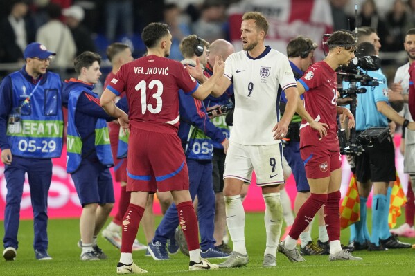 England's Harry Kane shakes hands with Serbia's Milos Veljkovic at the end of a Group C match between Serbia and England at the Euro 2024 soccer tournament in Gelsenkirchen, Germany, Sunday, June 16, 2024. (AP Photo/Andreea Alexandru)