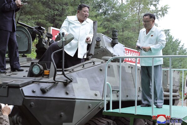 In this undated photo provided on Monday, Aug. 14, 2023, by the North Korean government, North Korean leader Kim Jong Un, center, rides on an armored vehicle during his Aug. 11-12 visit to a military factory in North Korea. Independent journalists were not given access to cover the event depicted in this image distributed by the North Korean government. The content of this image is as provided and cannot be independently verified. Korean language watermark on image as provided by source reads: 