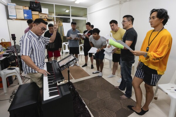 Voice coach Vuthipand Pongtanalert, left, instructs members of The Bangkok Gay Men's Chorus in a lesson in in Bangkok, Thailand, Sunday, Nov. 26, 2023. Thailand's Parliament is set to debate Thursday, Dec. 21, a final cabinet-endorsed draft bill to pass landmark legislation allowing members of the LGBTQ+ community to get married. (AP Photo/Sakchai Lalit)