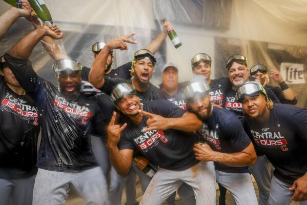 Cleveland Guardians players celebrate winning the American League Central in the locker room after defeating the Texas Rangers in a baseball game in Arlington, Texas, Sunday, Sept. 25, 2022. (AP Photo/Gareth Patterson)