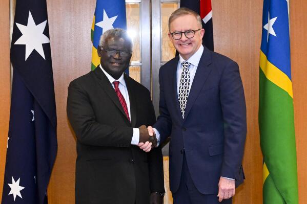 Australian Prime Minister Anthony Albanese, right, and Solomon Islands Prime Minister Manasseh Sogavare shake hands ahead of a bilateral meeting at Parliament House in Canberra, Australia, Thursday, Oct. 6, 2022. (Lukas Coch/AAP Image via AP)