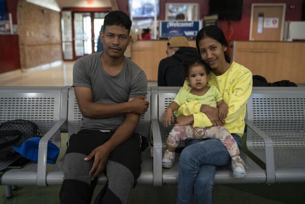 Venezuelan migrants Robert Granado, 26, his cousin, Lilibeth García Granado, 32, a doctor, and her daughter, Cataleya García Granado, 1, sit together for a portrait at a bus station in Brownsville, Texas, on Friday, Aug. 9, 2024, a day after crossing the border with a CBP One appointment. (Verónica Gabriela Cárdenas/The Texas Tribune via AP)