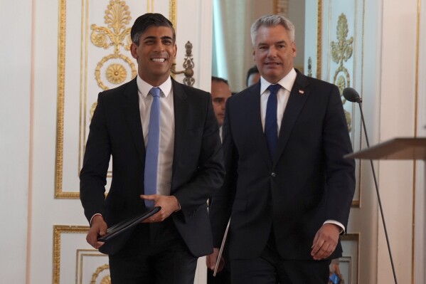 Prime Minister Rishi Sunak, left, arrives with the Chancellor of Austria, Karl Nehammer for a joint press conference, at Federal Chancellery Ballhausplatz in Vienna, during a visit to Austria, Tuesday May 21, 2024. (Jordan Pettitt/pool photo via AP)