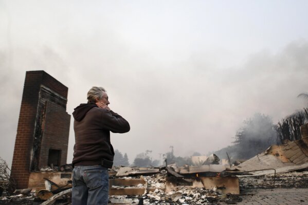 Greg Smith stands amid the ruins of his home after the Thomas fire swept through Ventura, Calif., Tuesday, Dec. 5, 2017. (Daniel Dreifuss via AP)