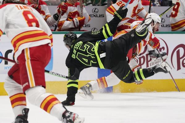 Dallas Stars left wing Fredrik Olofsson (42) and Calgary Flames defenseman Noah Hanifin (55) collide during the first period of an NHL hockey game in Dallas, Saturday, Jan. 14, 2023. (AP Photo/LM Otero)