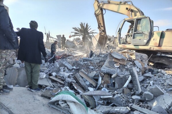 Members of the Iraqi Shiite Popular Mobilization Forces clean up debris after a U.S. airstrike in al-Qaim, Iraq, Saturday, February 3, 2024. U.S. Central Command said in a statement Friday that the U.S. military has struck more than 85 targets. against Iran's Islamic Revolutionary Guard Corps and its affiliated militias in Iraq and Syria.  (AP Photo/Popular Mobilization Forces News Bureau)