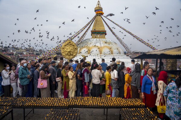 Buddhist devotees stand in a queue to light butter lamps during Buddha Jayanti or Buddha Purnima festival at the Boudhanath Stupa in Kathmandu, Nepal, Thursday, May 23, 2024. (AP Photo/Niranjan Shrestha)