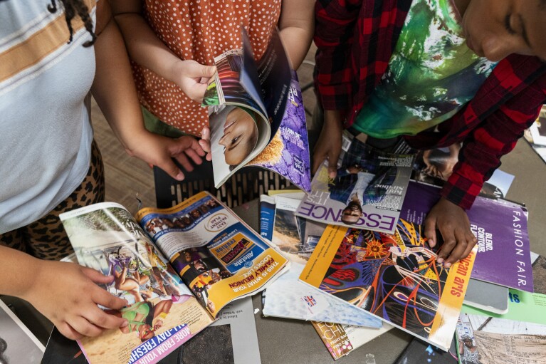 Campers look through magazines including Essence as they make a collage art project while attending Camp Be’chol Lashon, a sleepaway camp for Jewish children of color, Thursday, July 27, 2023, in Petaluma, Calif., at Walker Creek Ranch. Art projects encompass aspects of world cultures and incorporate Jewish elements. (AP Photo/Jacquelyn Martin)