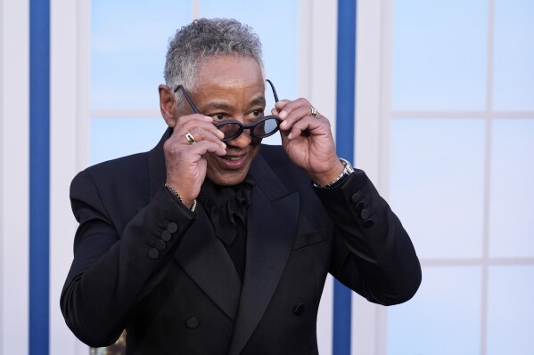 Giancarlo Esposito, a cast member in "The Residence," takes off his sunglasses for photographers at the premiere of the Netflix series at the Egyptian Theatre on Wednesday, March 19, 2025, in Los Angeles. (AP Photo/Chris Pizzello)