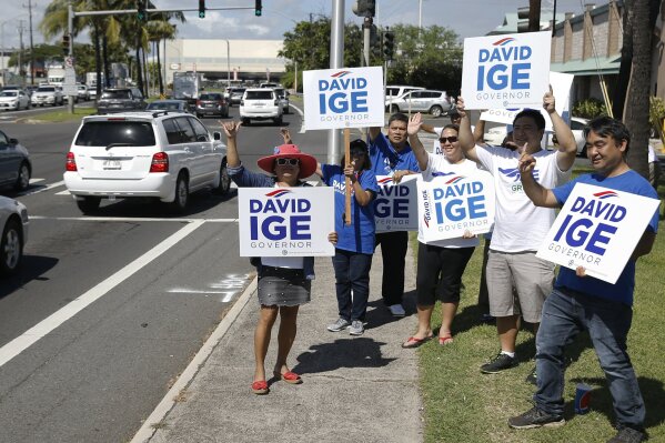 
              Supporters of Hawaii Gov. David Ige wave campaign signs at motorists, Tuesday, Nov. 6, 2018, in Honolulu. (AP Photo/Marco Garcia)
            