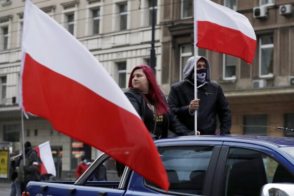 People take part in an annual Independence Day march organized by far-right groups, in Warsaw, Poland, on Wednesday, Nov.11, 2020. The march that marks Poland's sovereignty regained after World War I has often led to clashes with opponents. This year due to coronavirus and social distancing, the march took place in cars and motorbikes. (AP Photo/Czarek Sokolowski)