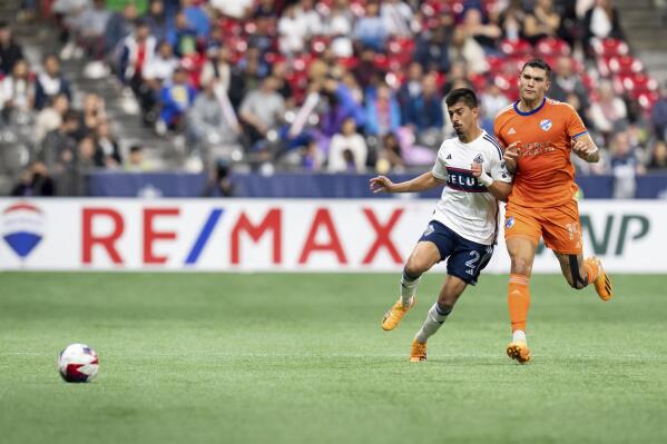 Vancouver Whitecaps' Mathias Laborda (2) and FC Cincinnati's Brandon Vazquez (19) chase the ball during the second half of an MLS soccer match in Vancouver, British Columbia, on Saturday, June 10, 2023. (Ethan Cairns/The Canadian Press via AP)