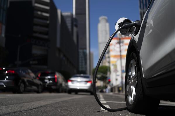 FILE - An electric vehicle is plugged into a charger in Los Angeles, on Aug. 25, 2022. People who want to buy an electric vehicle could get a bigger-than-expected tax credit come Jan. 1, 2023, because of a delay by the Treasury Department in drawing up rules for the tax breaks. (AP Photo/Jae C. Hong, File)