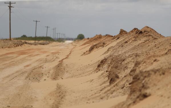 Sand that blew off farmers’ fields is piled up in a ditch outside Lingo, N.M., near the Texas-New Mexico border on Tuesday, May 18, 2021. The U.S. Department of Agriculture is encouraging farmers in a “Dust Bowl zone” that includes parts of Texas, New Mexico, Oklahoma, Kansas and Colorado to establish and preserve grasslands to prevent wind erosion as the area becomes increasingly dry. (AP Photo/Mark Rogers)
