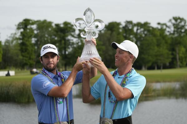 Davis Riley, left, and teammate Nick Hardy hoist their trophy after winning the PGA Zurich Classic golf tournament at TPC Louisiana in Avondale, La., Sunday, April 23, 2023. (AP Photo/Gerald Herbert)