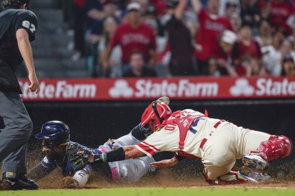 Los Angeles Angels catcher Logan O'Hoppe (14) tags out Tampa Bay Rays' Yandy Diaz to complete a triple play during the ninth inning of a baseball game Friday, Aug. 18, 2023, in Anaheim, Calif. Harold Ramirez hit a grounder to short; Randy Arozarena was forced out at second; Ramirez was thrown out at first; then Diaz was thrown out at home. (AP Photo/Ryan Sun)