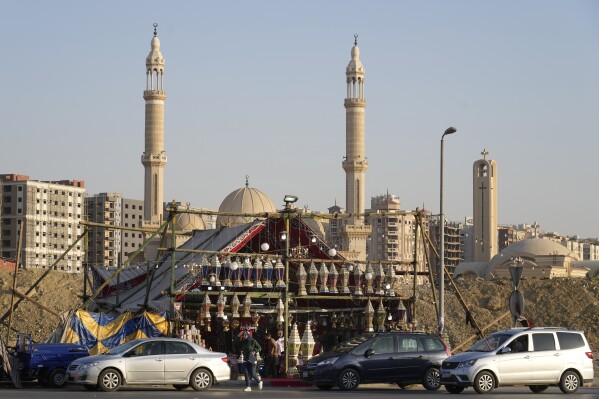 People buy traditional lanterns in front of a shop ahead of the upcoming Muslim fasting month of Ramadan, in Cairo, Egypt, Sunday, March 10, 2024. Muslims throughout the world are preparing to celebrate Ramadan, the holiest month in the Islamic calendar, refraining from eating, drinking, smoking and sex from sunrise to sunset. (AP Photo/Amr Nabil)