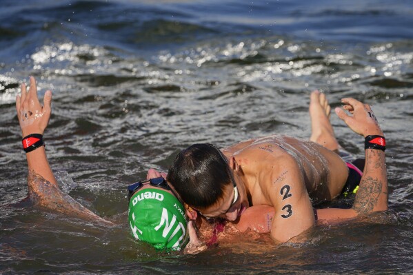 Gold medalist Hungary's Kristof Rasovszky, left, and bronze medalist Hungary's David Betlehem, right, embrace after crossing the finish line at the end of the marathon swimming men's 10km competition at the 2024 Summer Olympics, Friday, Aug. 9, 2024, in Paris, France. (AP Photo/Dar Yasin)