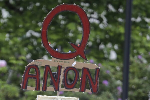 FILE - In this May 14, 2020 file photo, a person carries a sign supporting QAnon at a protest rally in Olympia, Wash.  Walmart, Amazon and other corporate giants donated money to a Tennessee state lawmaker’s re-election campaign after she used social media to amplify and promote the QAnon conspiracy theory. That's according to an Associated Press review of campaign finance records and online posts by Republican state Rep. Susan Lynn. (AP Photo/Ted S. Warren, File)