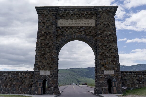 Vehicles block the entrance to Yellowstone National Park, a major tourist attraction now closed due to the historic floodwaters, June 15, 2022, in Gardiner, Mont. (AP Photo/David Goldman, File)
