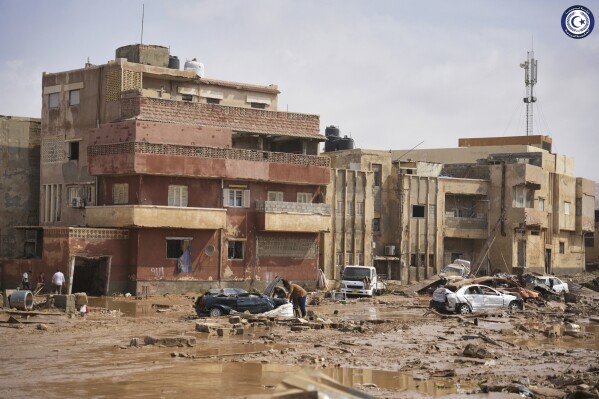 In this photo provided by the Libyan government, cars and rubble sit in a street in Derna, Libya, on Monday, Sept. 11, 2023, after it was flooded by heavy rains. Mediterranean storm Daniel caused devastating floods in Libya that broke dams swept away entire neighborhoods and wrecked homes in multiple coastal towns in the east of the North African nation. As many as 2,000 people were feared dead one of the country's leaders said. (Libyan government via AP)
