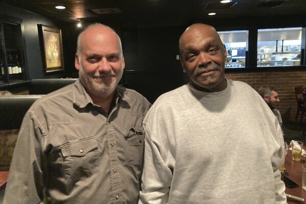 CORRECTS DATE OF CONVICTION REVERSAL TO TWO YEARS AGO NOT TUESDAY - In this photo provided by James Comstock, John Lewis, left, stands with Jesse Johnson at a restaurant in Lake Oswego, Ore., Tuesday, Sept. 5, 2023. Johnson, convicted of a 1998 murder and sentenced to death, is now free, two years after the Oregon Court of Appeals reversed the conviction. Prosecutors asked for the case to be dismissed, saying that with the passage of time, the state no longer believes that it can prove Johnson was guilty. Johnson has always maintained his innocence. (James Comstock via AP)