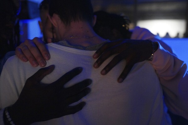 Aaron Dews and Jonathan Diggs place hands Noah Officer as they pray together at The Cove, a pop-up, 18-and-up Christian nightclub, on Saturday, Feb. 17, 2024, in Nashville, Tenn.  The Cove was started last year by seven Black Christian men in their 20s who sought to build a thriving community and a welcoming space for young adults outside houses of worship.  (AP Photo/Jessie Wardarski)