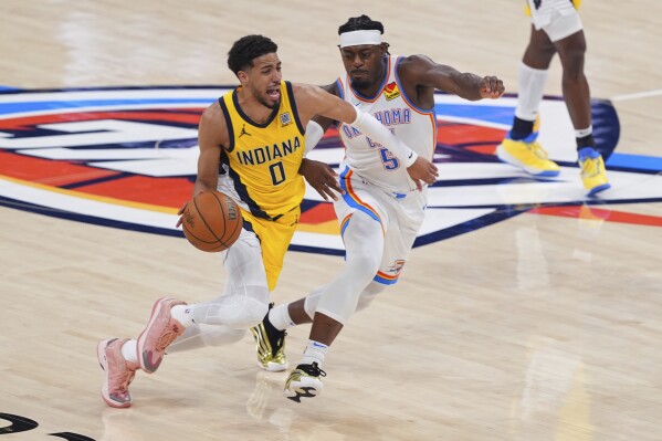Indiana Pacers guard Tyrese Haliburton (0) drives past Oklahoma City Thunder guard Luguentz Dort (5) during the second half of Game 5 of the NBA Finals basketball series, Monday, June 16, 2025, in Oklahoma City. (AP Photo/Kyle Phillips)