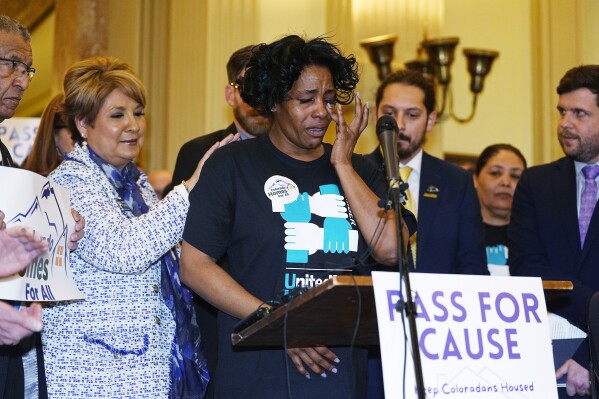 Monique Gant, center, of Westminster, Colo., recounts her experience of being evicted while being consoled by Colorado House Majority Leader Monica Duran during a rally to unveil an eviction protections bill being advanced by Democratic lawmakers Wednesday, Jan. 24, 2024, in Denver. Monthly rent has outpaced income across the U.S., and forced many to make tough decisions between everyday necessities and a home. In turn, a record number of people are becoming homeless and evictions filings have ratcheted up as pandemic-era eviction moratoriums and federal assistance ends. (AP Photo/David Zalubowski)