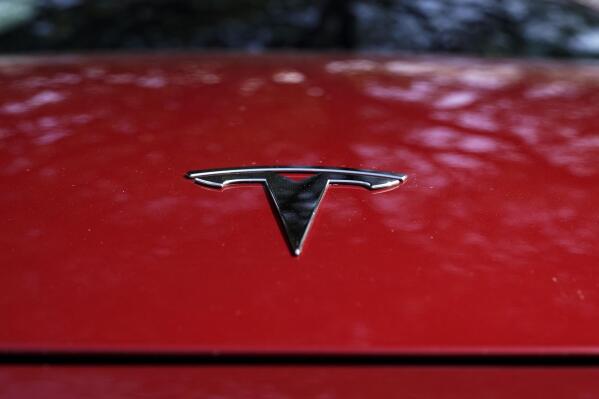 FILE - A Tesla logo is seen on a vehicle on display in Austin, Texas, Wednesday, Feb. 22, 2023. On Wednesday, March 1, Tesla executives said the company will use innovative manufacturing techniques and smaller factories to cut the cost of its next generation of vehicles by as much as half of the ones it now builds. (AP Photo/Eric Gay, File)