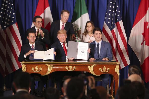 FILE - In this Nov. 30, 2018 file photo, President Donald Trump, center, sits between Canada's Prime Minister Justin Trudeau, right, and Mexico's President Enrique Pena Nieto after they signed a new United States-Mexico-Canada Agreement that is replacing the NAFTA trade deal, during a ceremony at a hotel before the start of the G20 summit in Buenos Aires, Argentina. U.S. and Mexican unions have filed on Monday, May 10, 2021, the first labor complaint against Mexico under the U.S.-Mexico-Canada free trade pact.  (AP Photo/Martin Mejia, file)