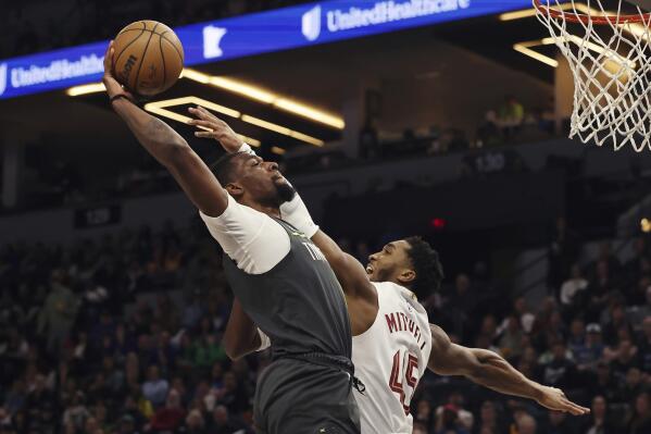 Minnesota Timberwolves center Naz Reid (11) goes to the basket against Cleveland Cavaliers guard Donovan Mitchell (45) during the first half of an NBA basketball game Saturday, Jan. 14, 2023, in Minneapolis. (AP Photo/Stacy Bengs)